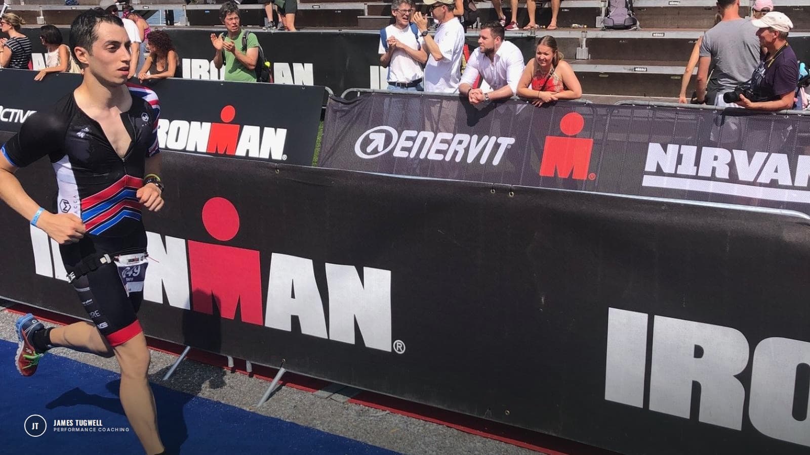 James Tugwell running past the crowd barriers on the finishing stretch of an Ironman