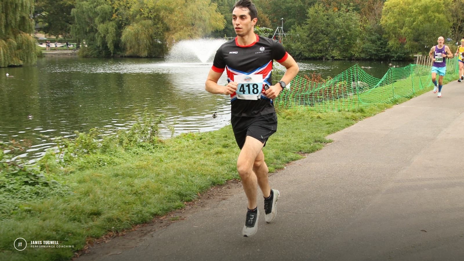 James Tugwell racing along a lakeside path in a running race