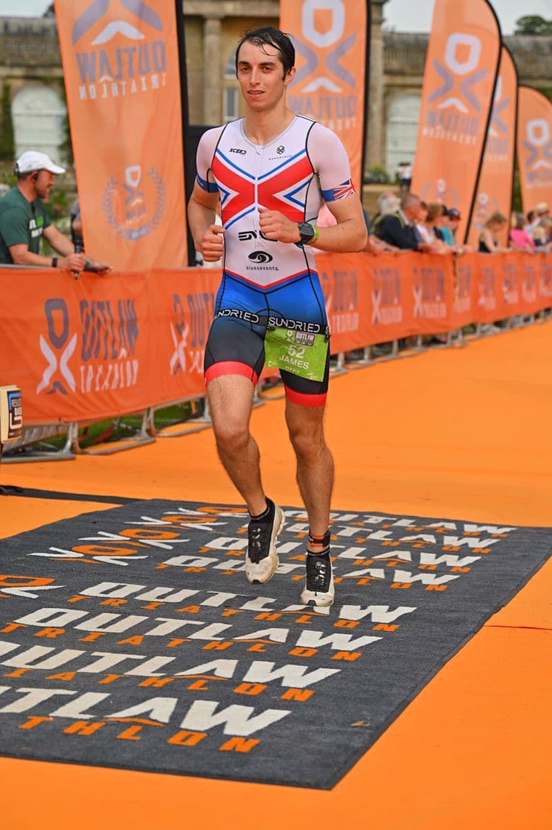 James crossing the finish line at the Outlaw triathlon