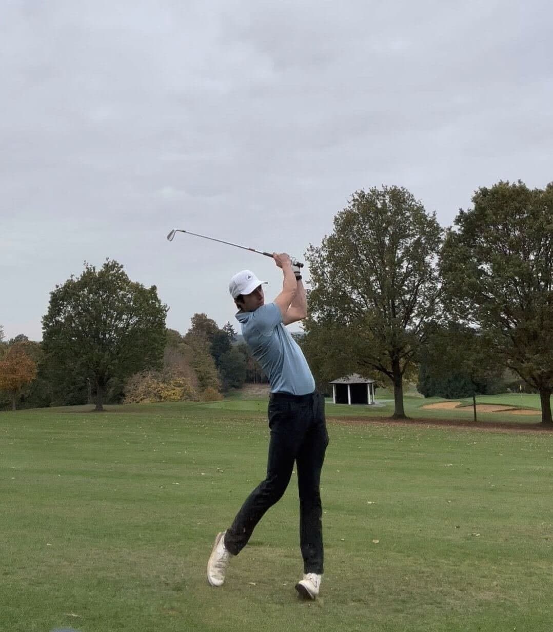 James Tugwell at the top of his golf backswing on the fairway
